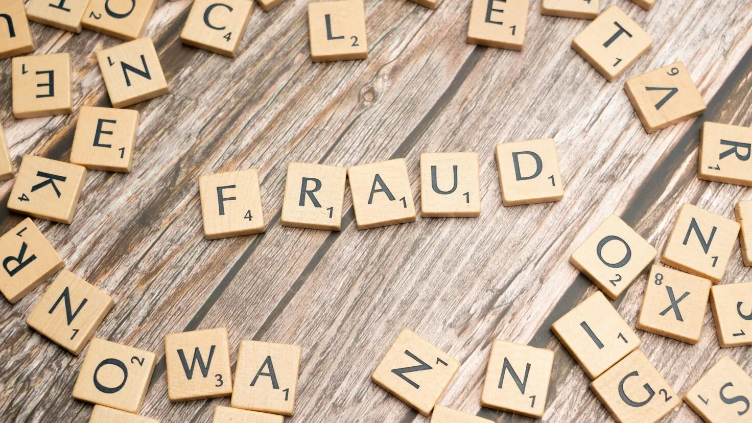 scrabble tiles spelling out the word fraud