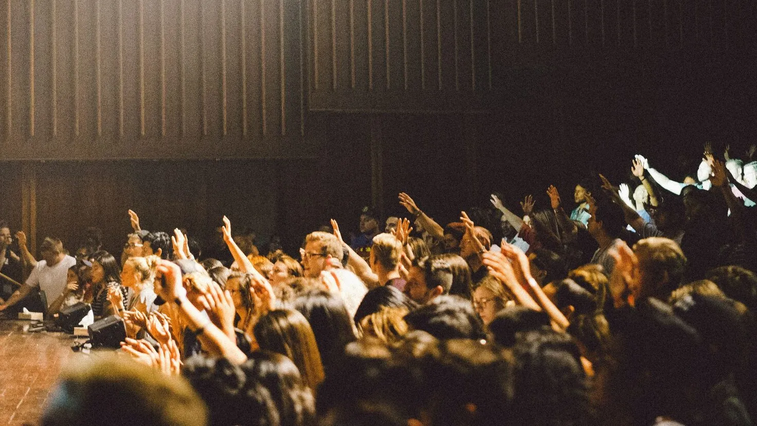 people raising their hands to ask questions in a lecture hall