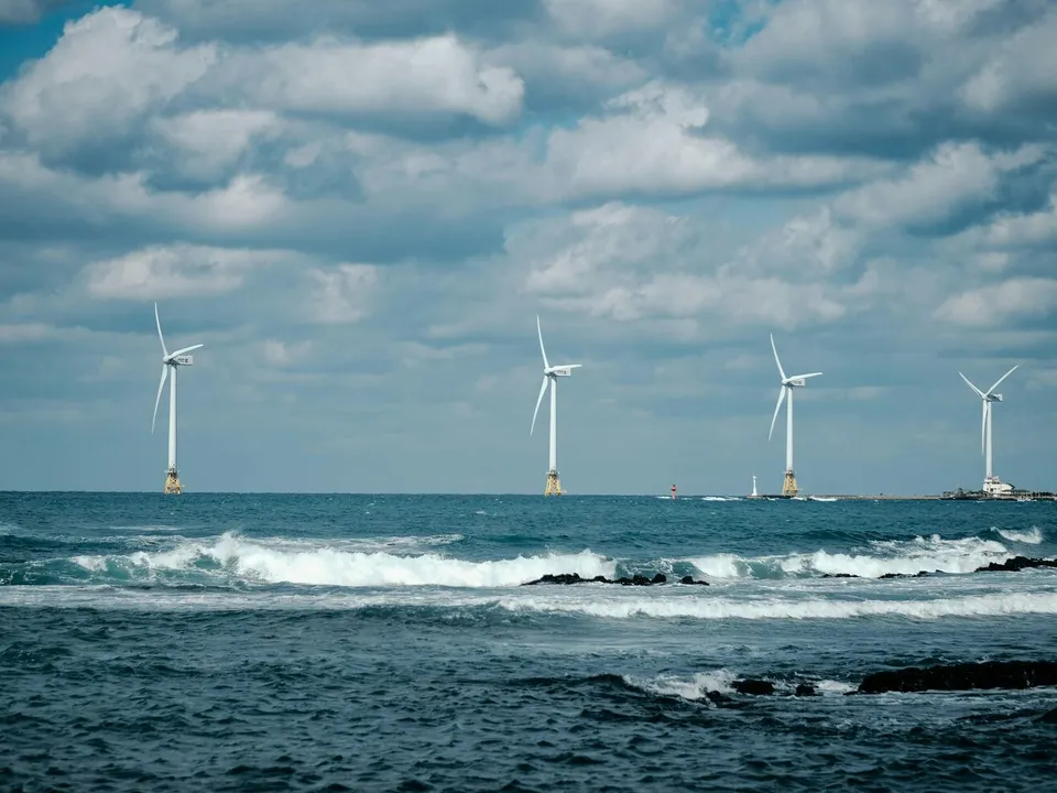 row of wind turbines at sea