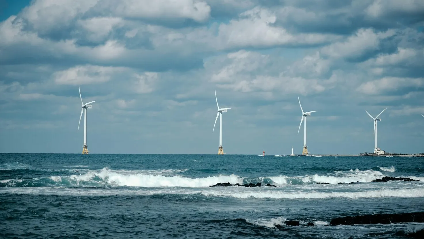row of wind turbines at sea