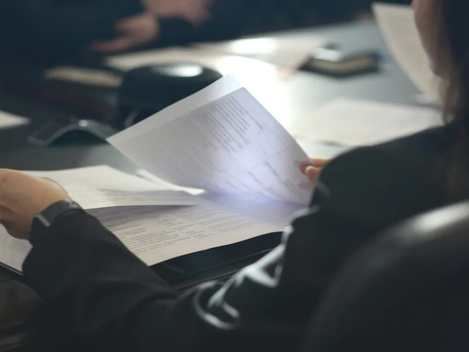woman sitting at a table reading a paper