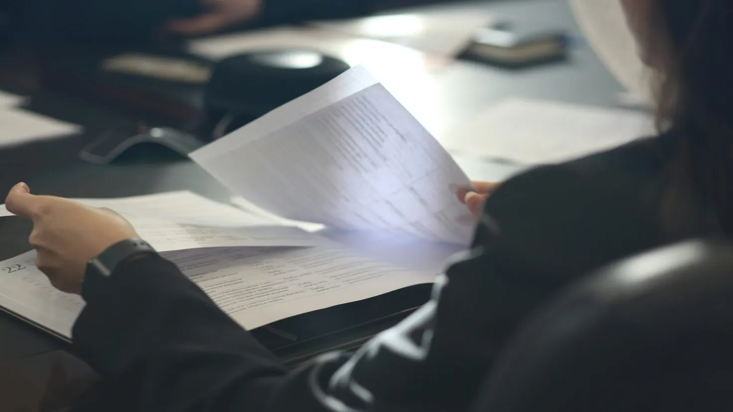 woman sitting at a table reading a paper