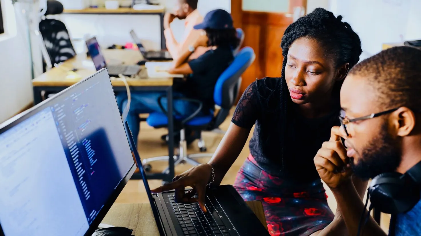 woman and man sitting in front of monitor